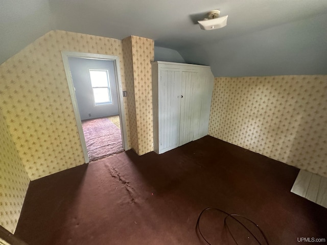 bonus room with carpet floors and vaulted ceiling