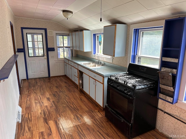 kitchen featuring lofted ceiling, white cabinets, black gas stove, sink, and dark hardwood / wood-style floors