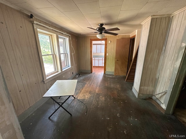 interior space featuring wood walls, dark hardwood / wood-style flooring, and ceiling fan