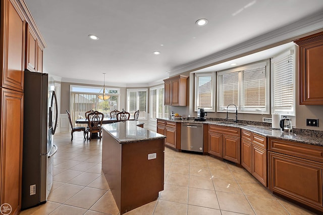 kitchen featuring pendant lighting, light tile patterned floors, sink, appliances with stainless steel finishes, and a center island