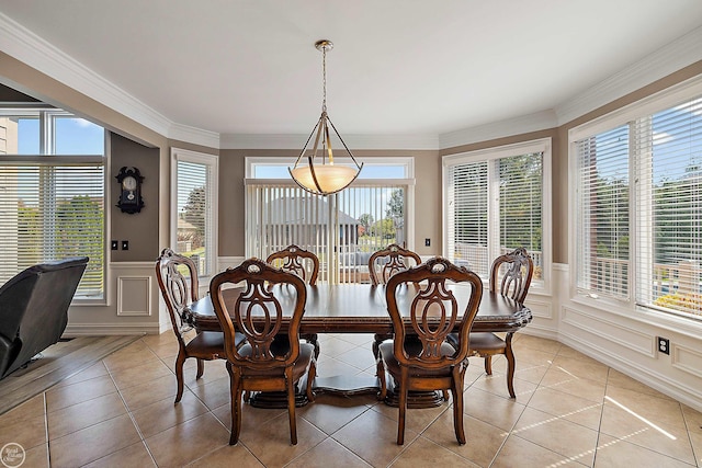 dining space with ornamental molding and light tile patterned floors