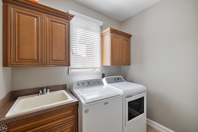 laundry area with separate washer and dryer, sink, and cabinets