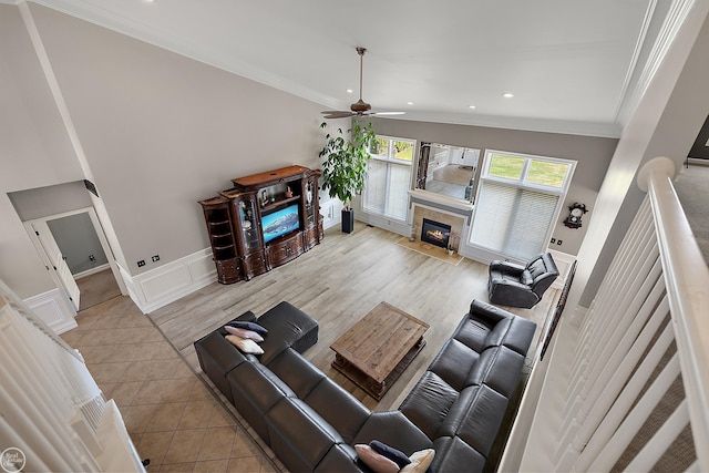 living room featuring ornamental molding, vaulted ceiling, ceiling fan, and light hardwood / wood-style floors