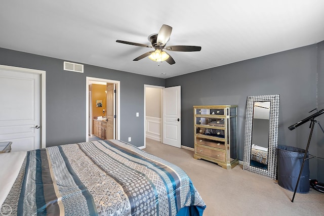 carpeted bedroom featuring ceiling fan and ensuite bath