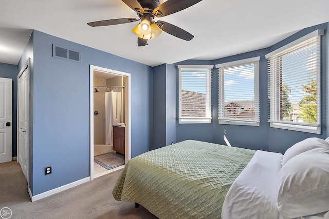 carpeted bedroom featuring ensuite bath, ceiling fan, and a closet