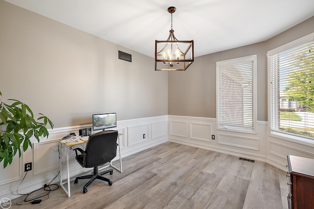 office area with light wood-type flooring, an inviting chandelier, and plenty of natural light