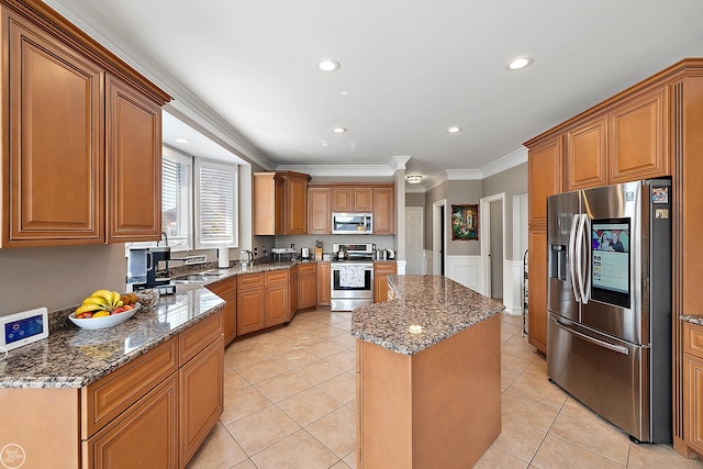 kitchen featuring light tile patterned floors, a kitchen island, appliances with stainless steel finishes, dark stone counters, and crown molding