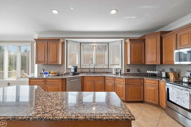 kitchen with ornamental molding, stainless steel appliances, sink, and dark stone counters