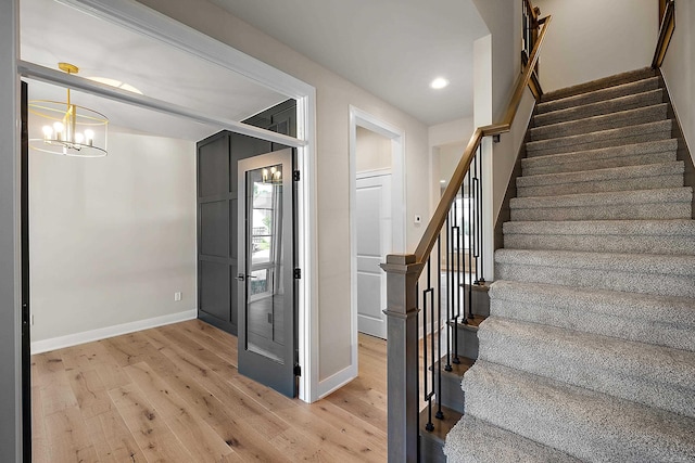 foyer with light hardwood / wood-style floors and a chandelier