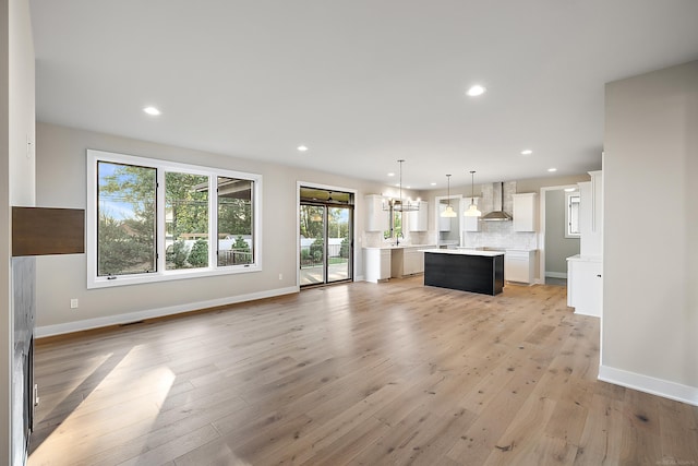 unfurnished living room with light wood-type flooring and sink