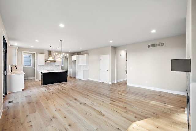 unfurnished living room featuring light hardwood / wood-style flooring and sink