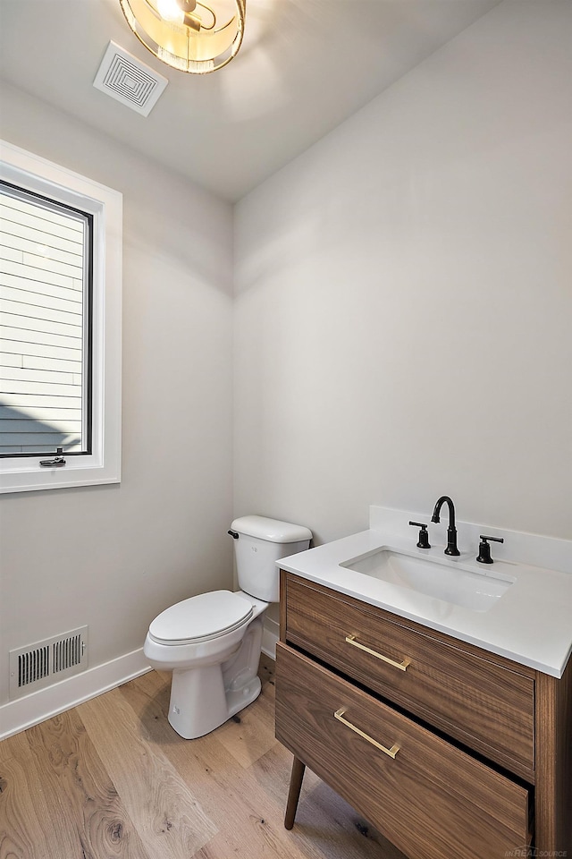 bathroom featuring wood-type flooring, vanity, and toilet