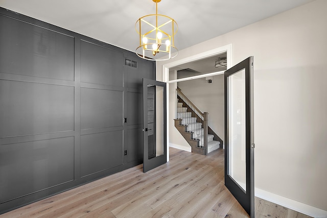 interior space with light hardwood / wood-style floors and an inviting chandelier