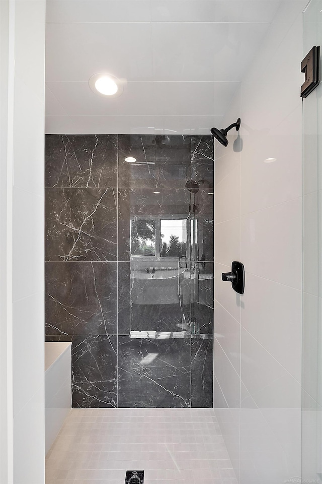 bathroom featuring a tile shower and tile walls