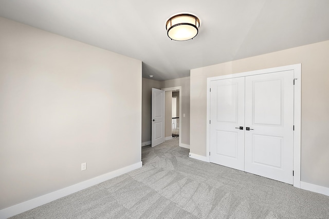 unfurnished bedroom with light carpet and a closet