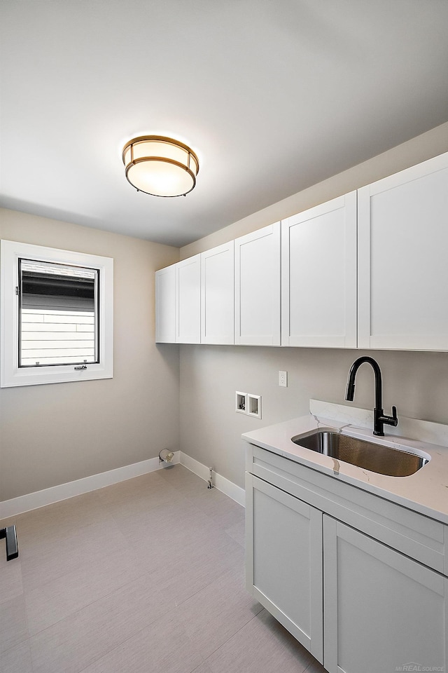 washroom featuring washer hookup, cabinets, and sink