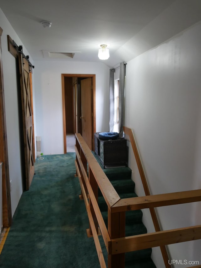 interior space with dark colored carpet and a barn door