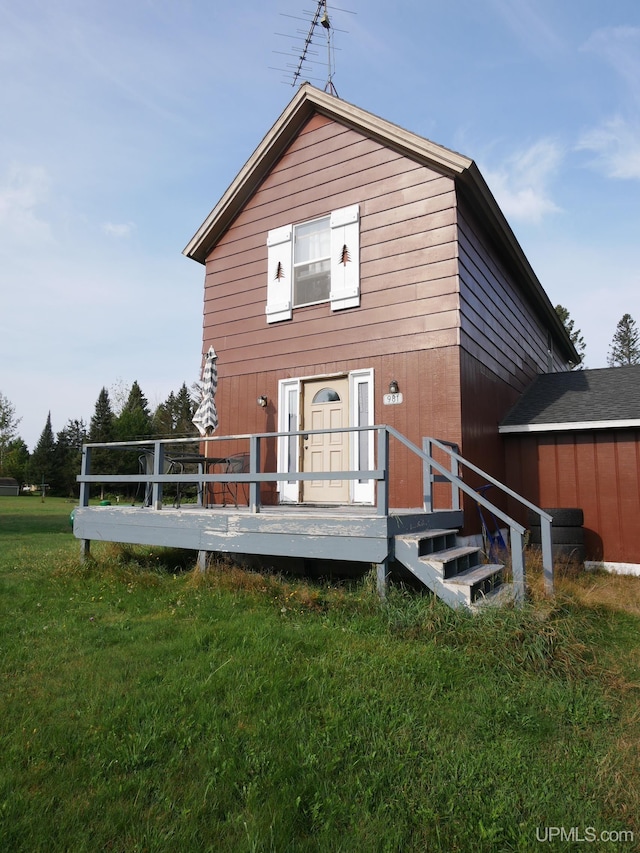 rear view of house featuring a yard and a deck