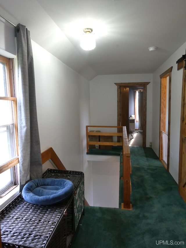 hallway featuring carpet floors and vaulted ceiling