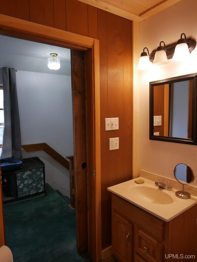 bathroom with wood walls and vanity