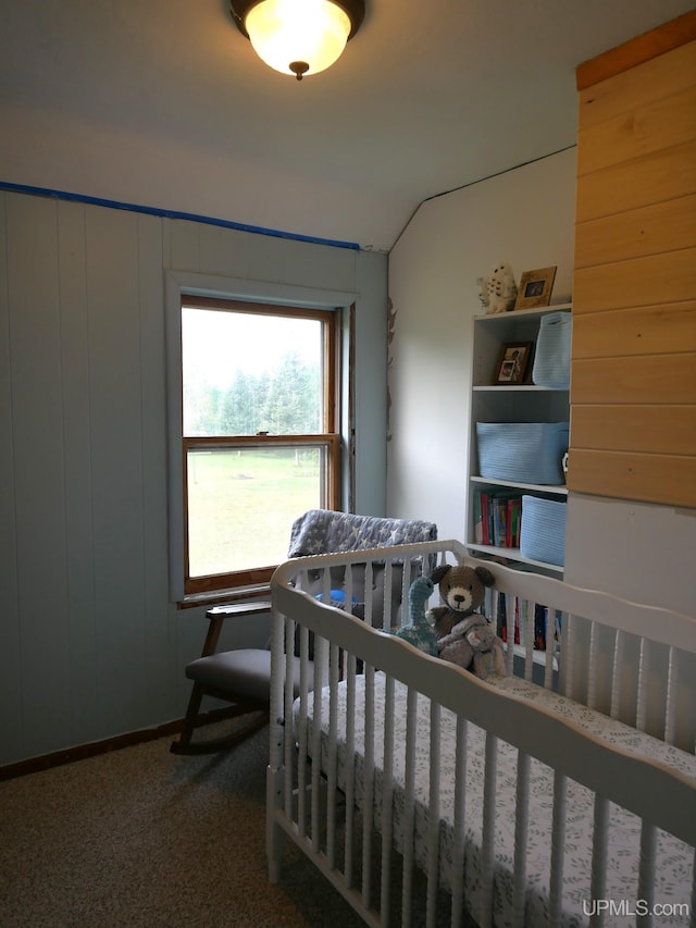 carpeted bedroom featuring wooden walls