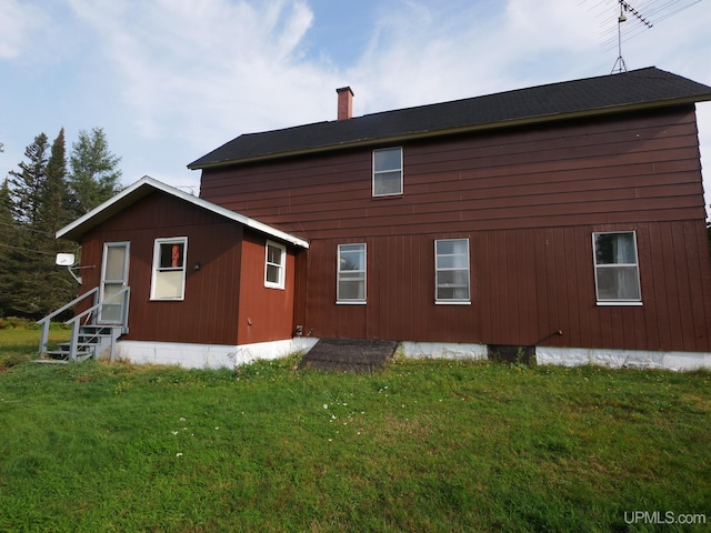 rear view of house featuring a yard