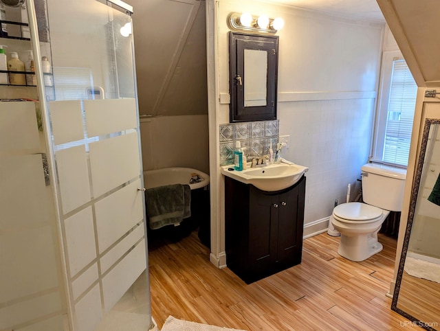 bathroom featuring vanity, ornamental molding, wood-type flooring, backsplash, and toilet