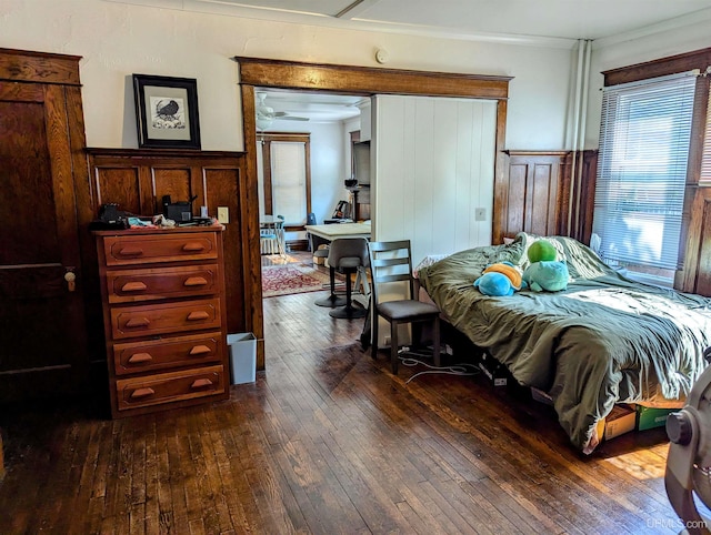 bedroom with ornamental molding and dark hardwood / wood-style floors