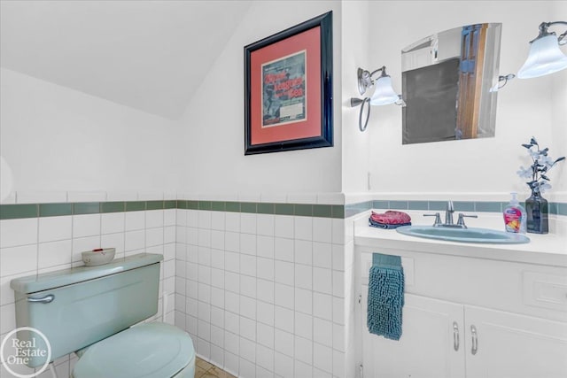 bathroom featuring tile walls, decorative backsplash, vaulted ceiling, vanity, and toilet