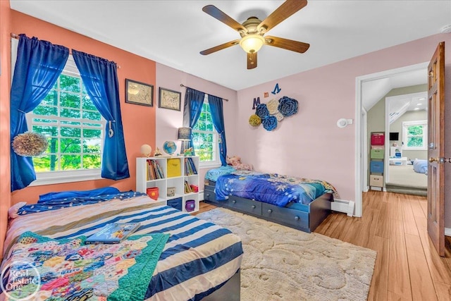 bedroom with ceiling fan, multiple windows, and hardwood / wood-style floors