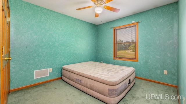 carpeted bedroom with visible vents, a ceiling fan, and baseboards