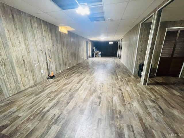 corridor featuring hardwood / wood-style flooring and a paneled ceiling