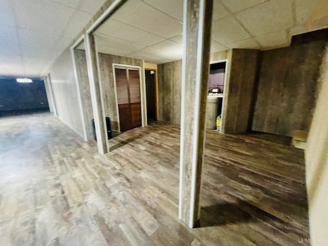 basement with a drop ceiling and hardwood / wood-style floors