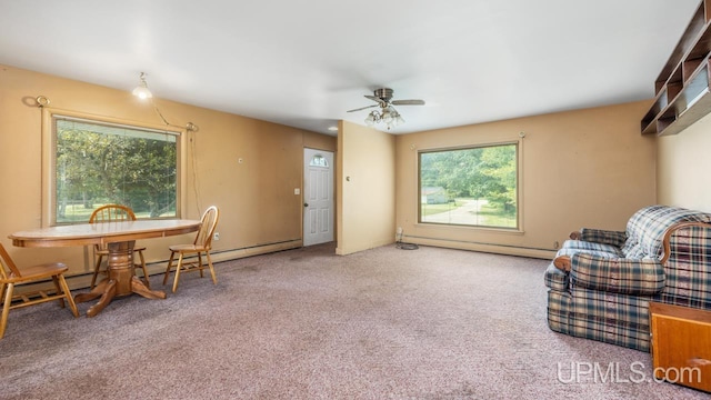 sitting room featuring ceiling fan, baseboard heating, plenty of natural light, and carpet