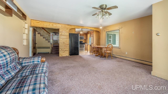 unfurnished living room featuring ceiling fan, a baseboard heating unit, carpet, and radiator heating unit