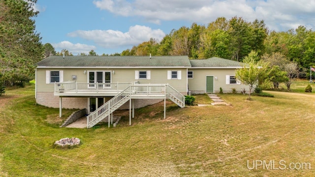 back of house featuring a wooden deck and a yard