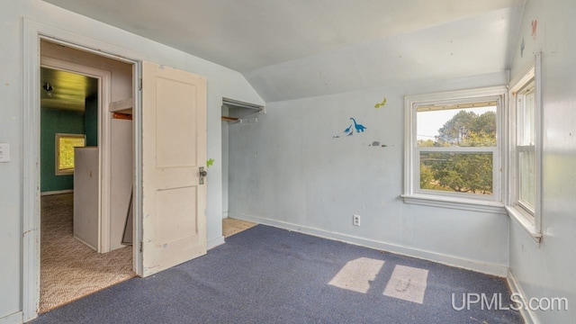 interior space featuring carpet floors and vaulted ceiling