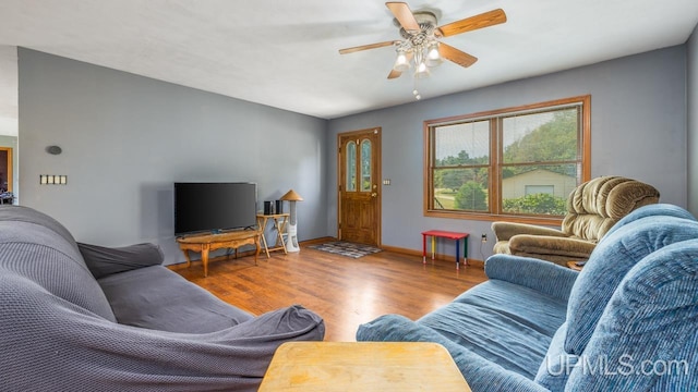 living room featuring wood finished floors, baseboards, and ceiling fan