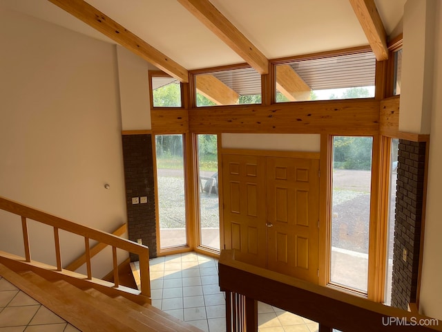 tiled entrance foyer featuring vaulted ceiling with beams