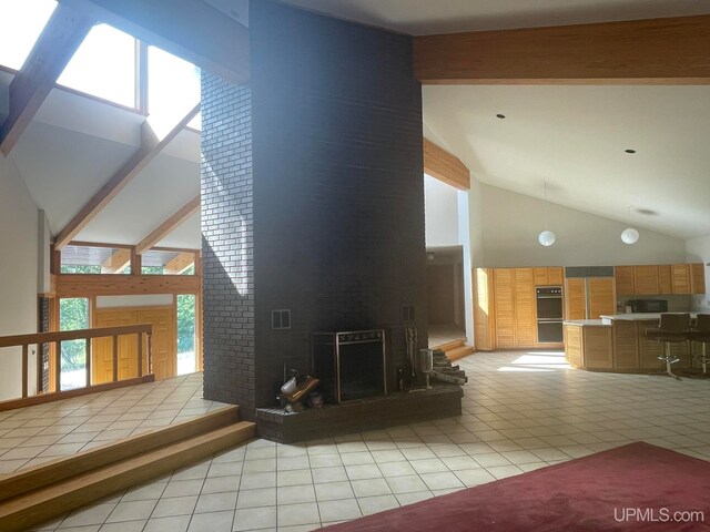 living room featuring a fireplace, light tile patterned flooring, and high vaulted ceiling