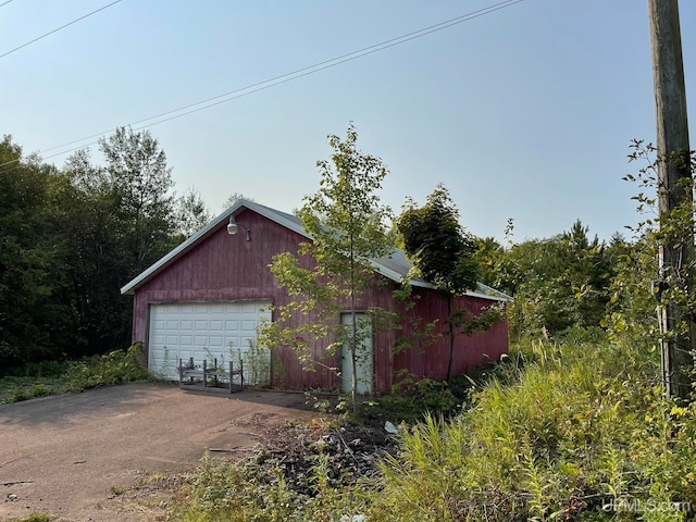 view of side of property with an outdoor structure and a garage