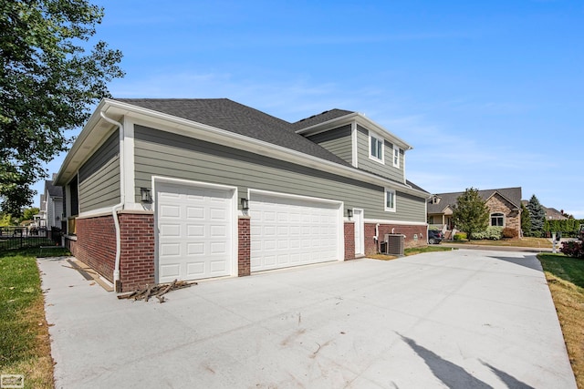 view of home's exterior with a garage and central AC