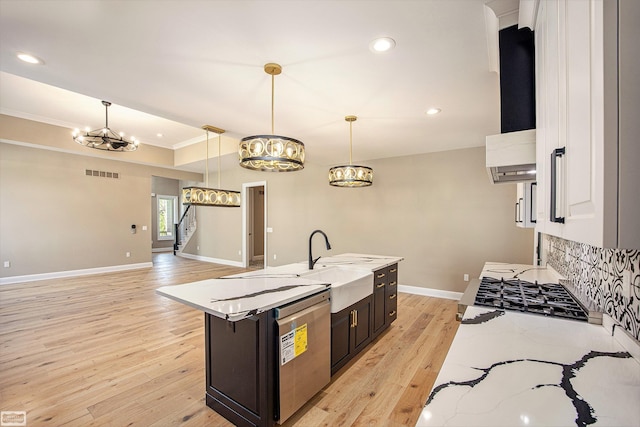 kitchen featuring light hardwood / wood-style floors, sink, ventilation hood, hanging light fixtures, and ornamental molding