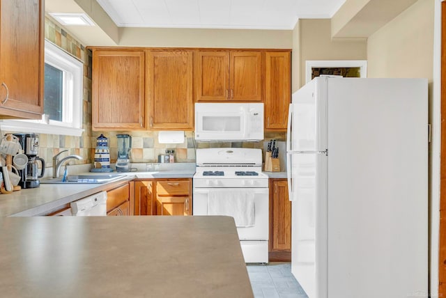 kitchen featuring crown molding, backsplash, sink, and white appliances