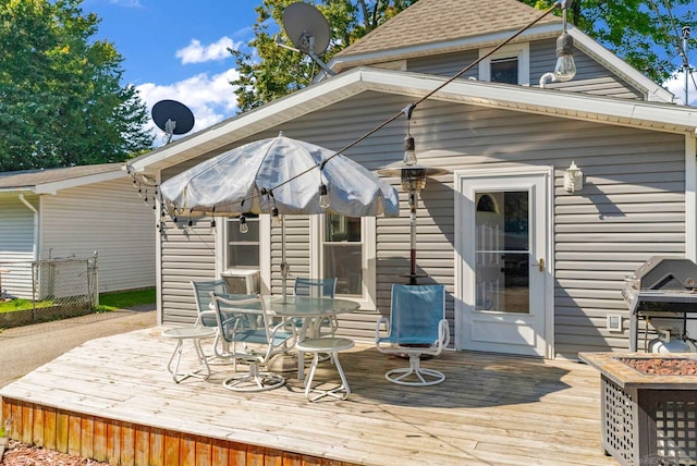 wooden terrace featuring grilling area and an outdoor fire pit