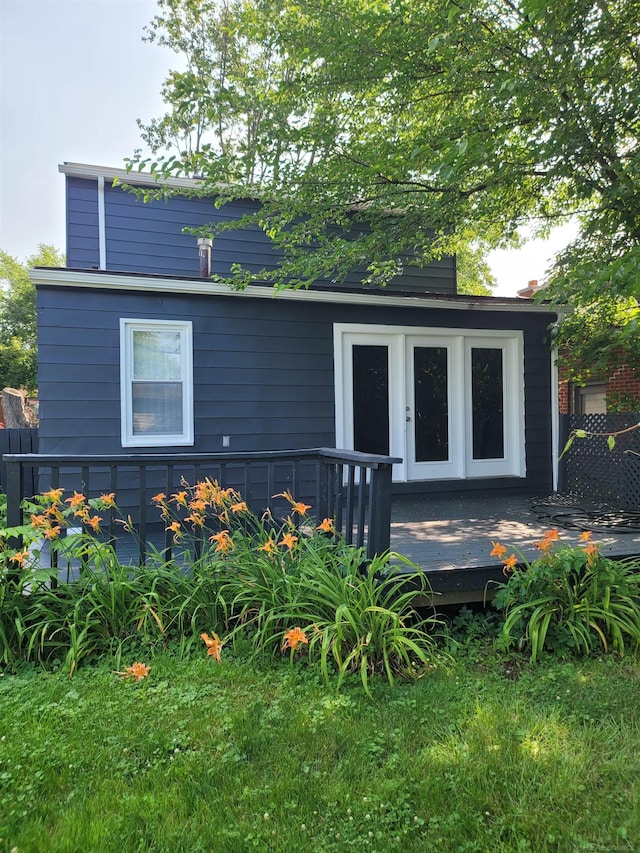 view of front facade with a wooden deck and french doors