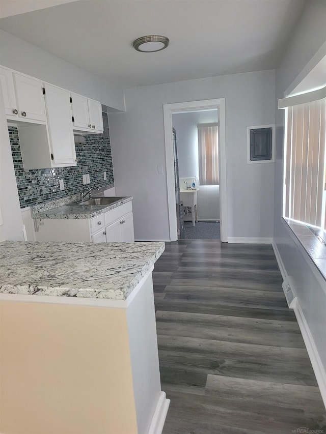 kitchen featuring a wealth of natural light, dark wood-type flooring, sink, and white cabinetry