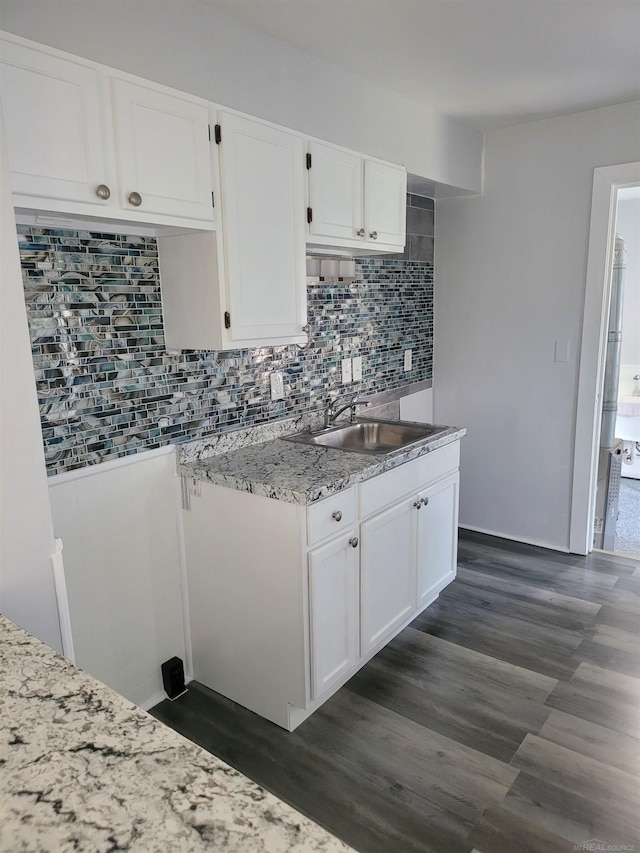 kitchen with dark hardwood / wood-style floors, white cabinetry, and sink