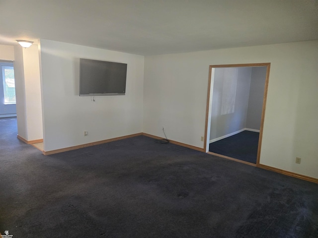 unfurnished room with dark colored carpet