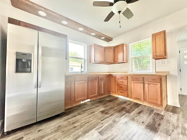 kitchen featuring ceiling fan, stainless steel fridge with ice dispenser, dark wood-type flooring, and a wealth of natural light